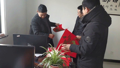 公司員工歡歡喜喜帖春聯(lián)，喜迎新春